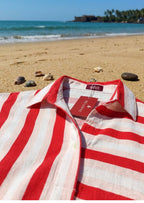 Red and white striped shirt on a beach with ocean and rocks in the background