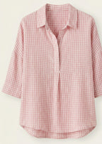 Pink and white checkered shirt on a light beige background
