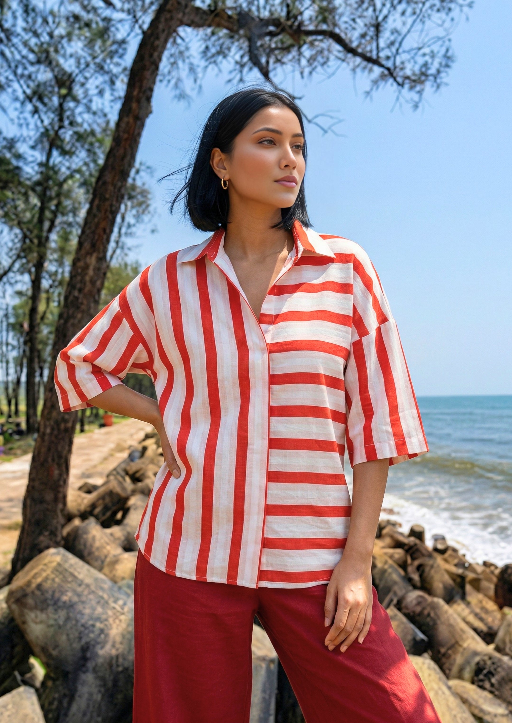 Woman wearing a red and white striped shirt by the beach
