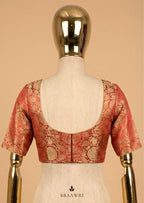 Red and gold blouse on a mannequin against a beige background