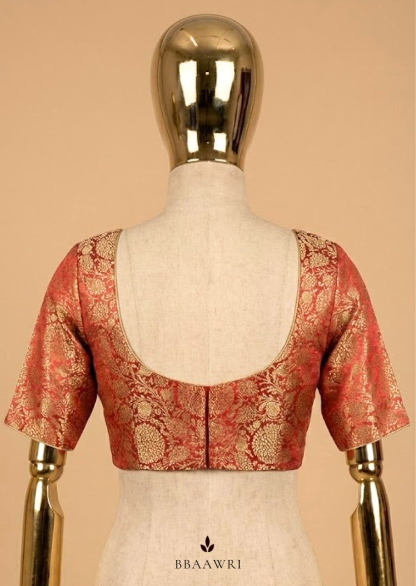 Red and gold blouse on a mannequin against a beige background