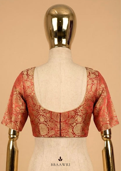 Red and gold blouse on a mannequin against a beige background