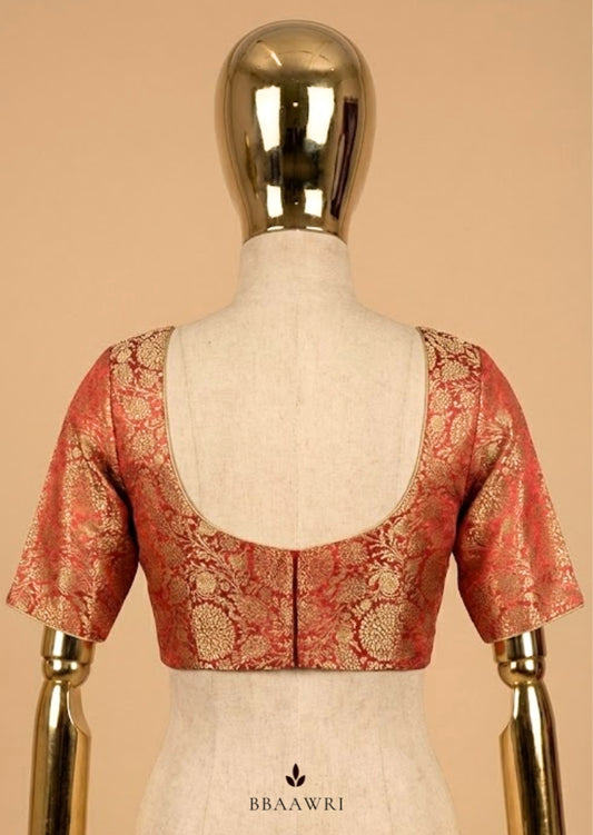 Red and gold blouse on a mannequin against a beige background