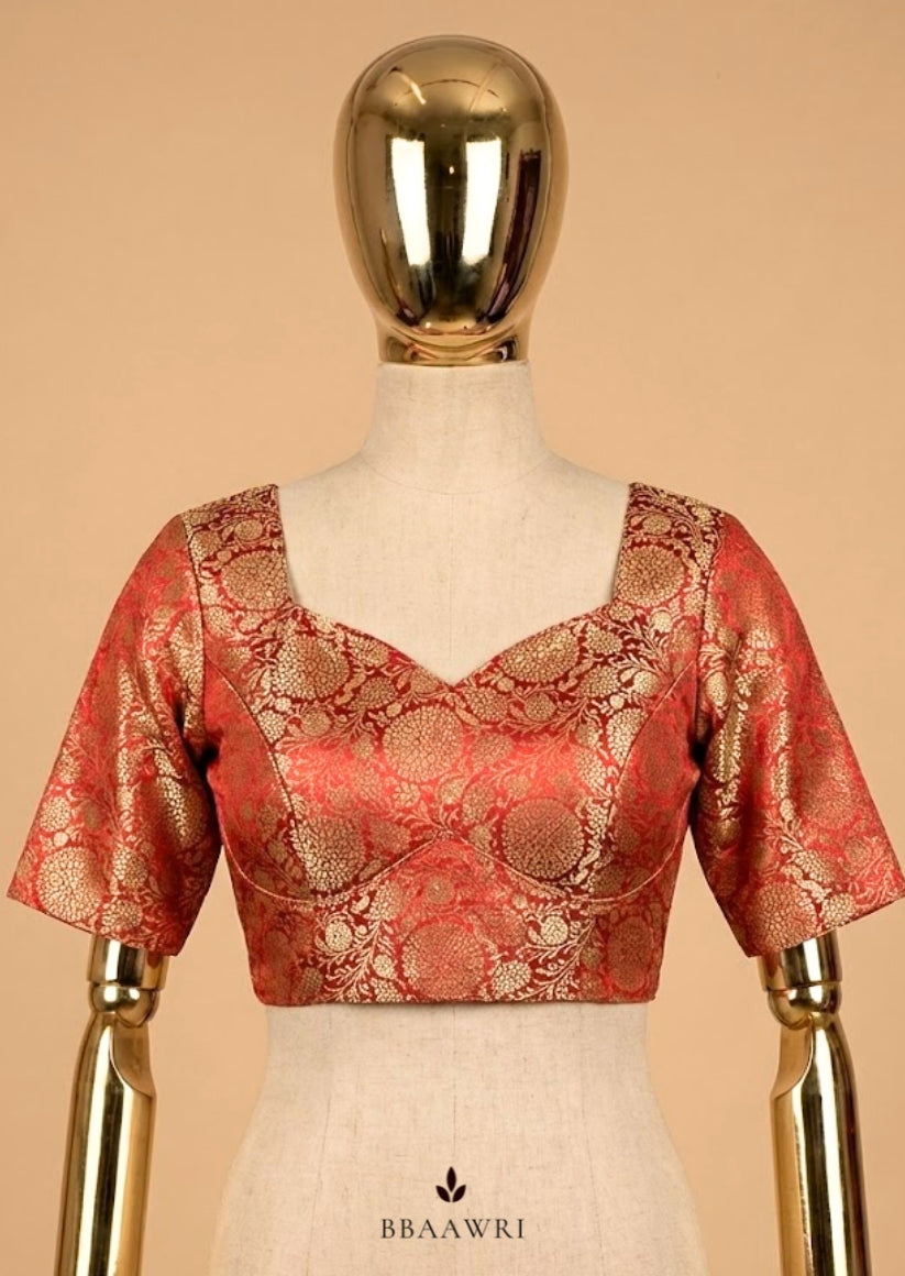 Red and gold blouse on a mannequin against a beige background