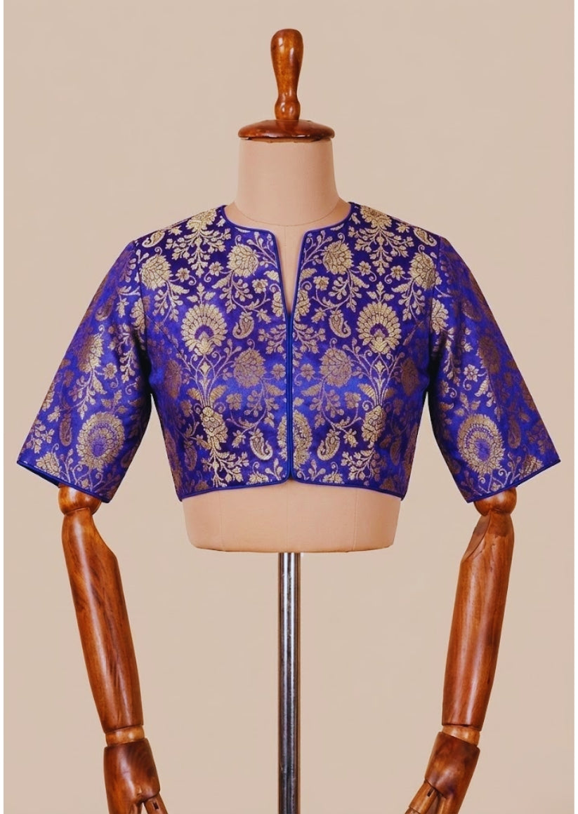 Blue embroidered blouse on a mannequin against a beige background