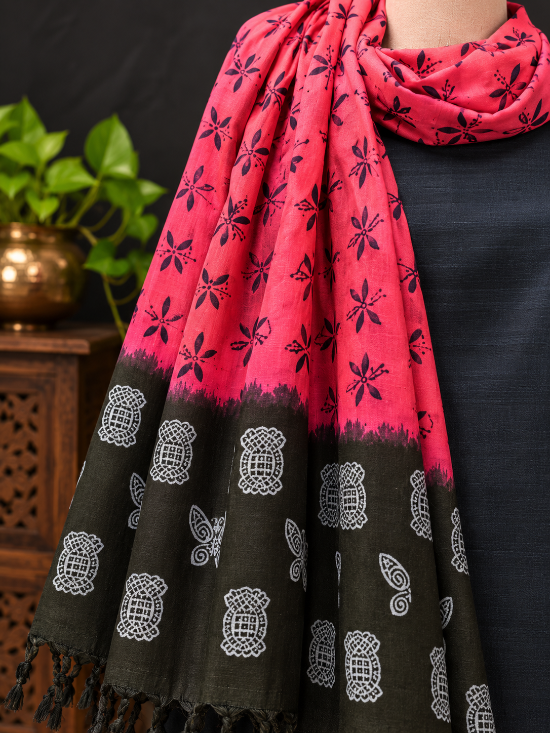 A draped Vibrant_Pink_and_Charcoal_Printed_Dupatta in bright pink and dark charcoal gray with black and white block-print patterns, styled over a dark navy top.